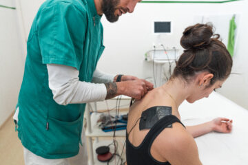 Tens Con elettrodi applicati dall'operartore sanitario sulla schiena della paziente